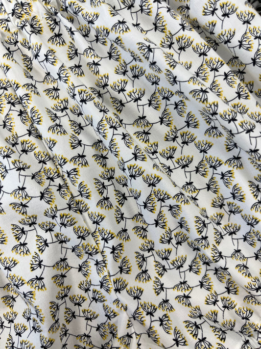 Fabric with a pattern made of small black and yellow dandelion