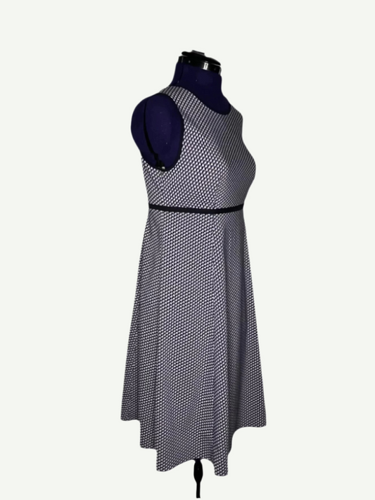 White, purple and navy patterned dress on a mannequin, featuring a round neckline and an empire-style design.