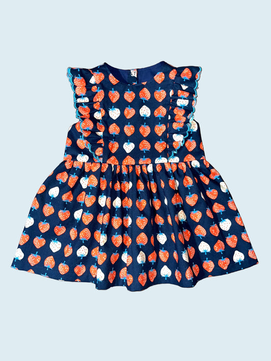 Children's dress with red and white strawberry pattern on navy background. 
