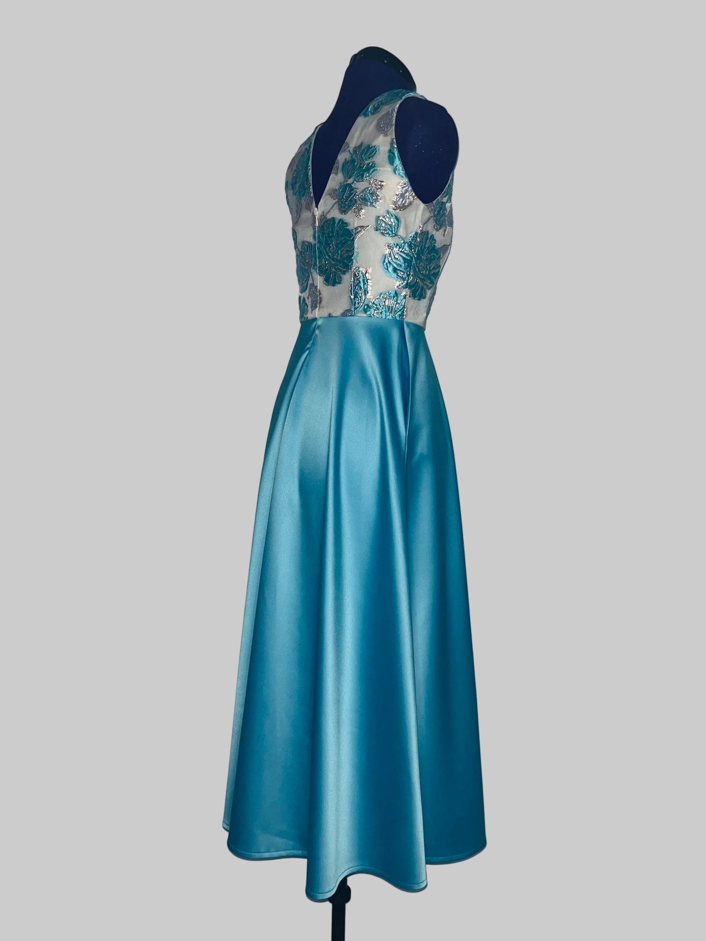 Blue dress with floral lace top on a mannequin against a white background