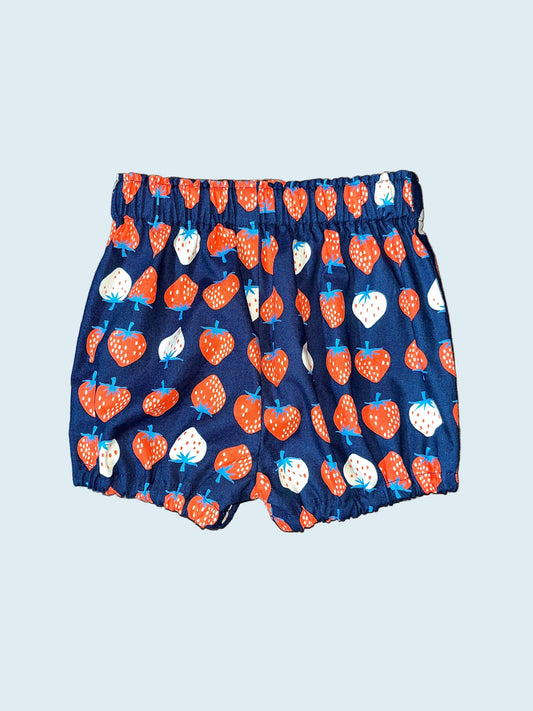 Navy bloomers with white and red strawberry pattern on a light blue surface