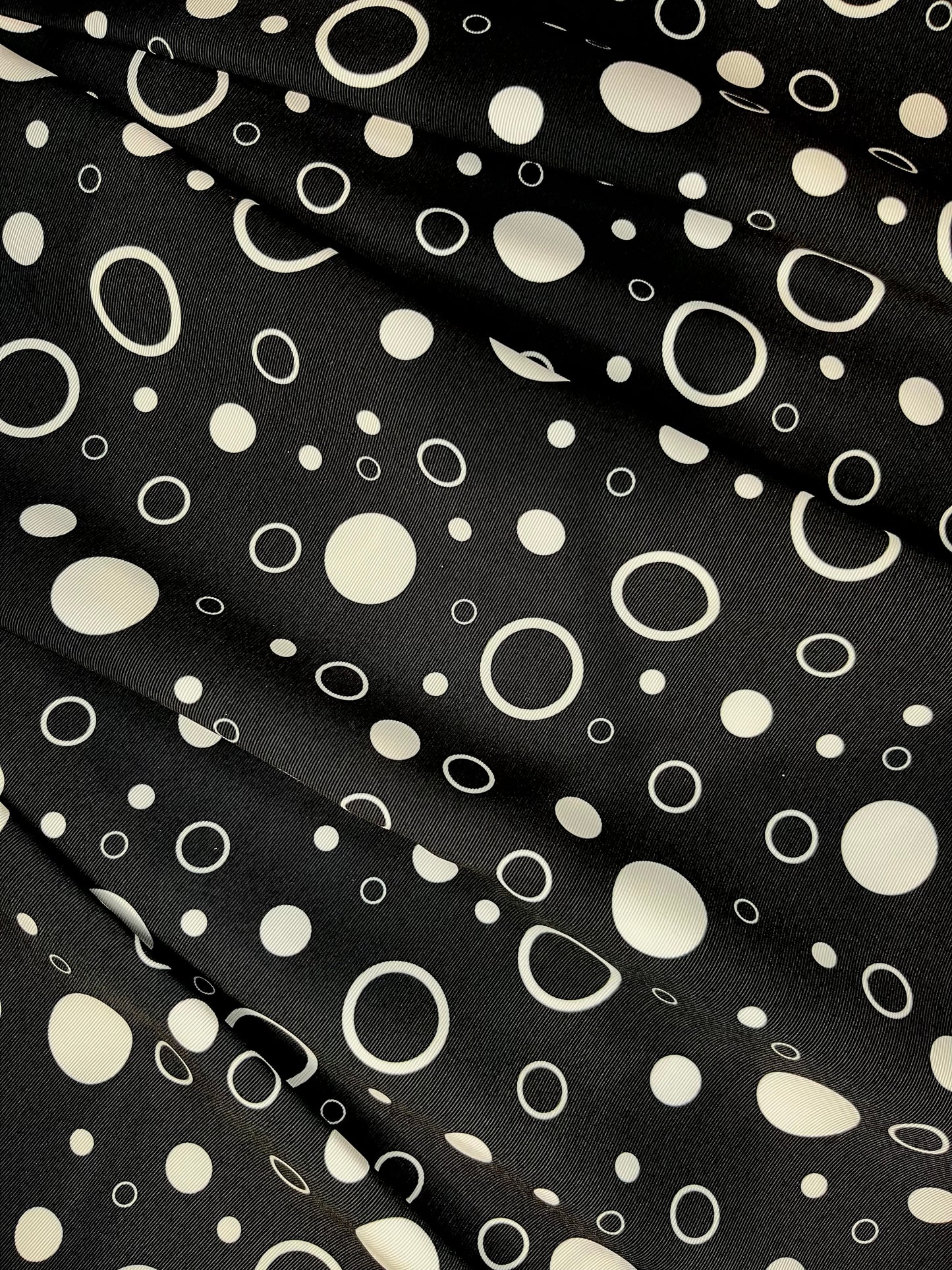 Black fabric with white polka dot pattern.