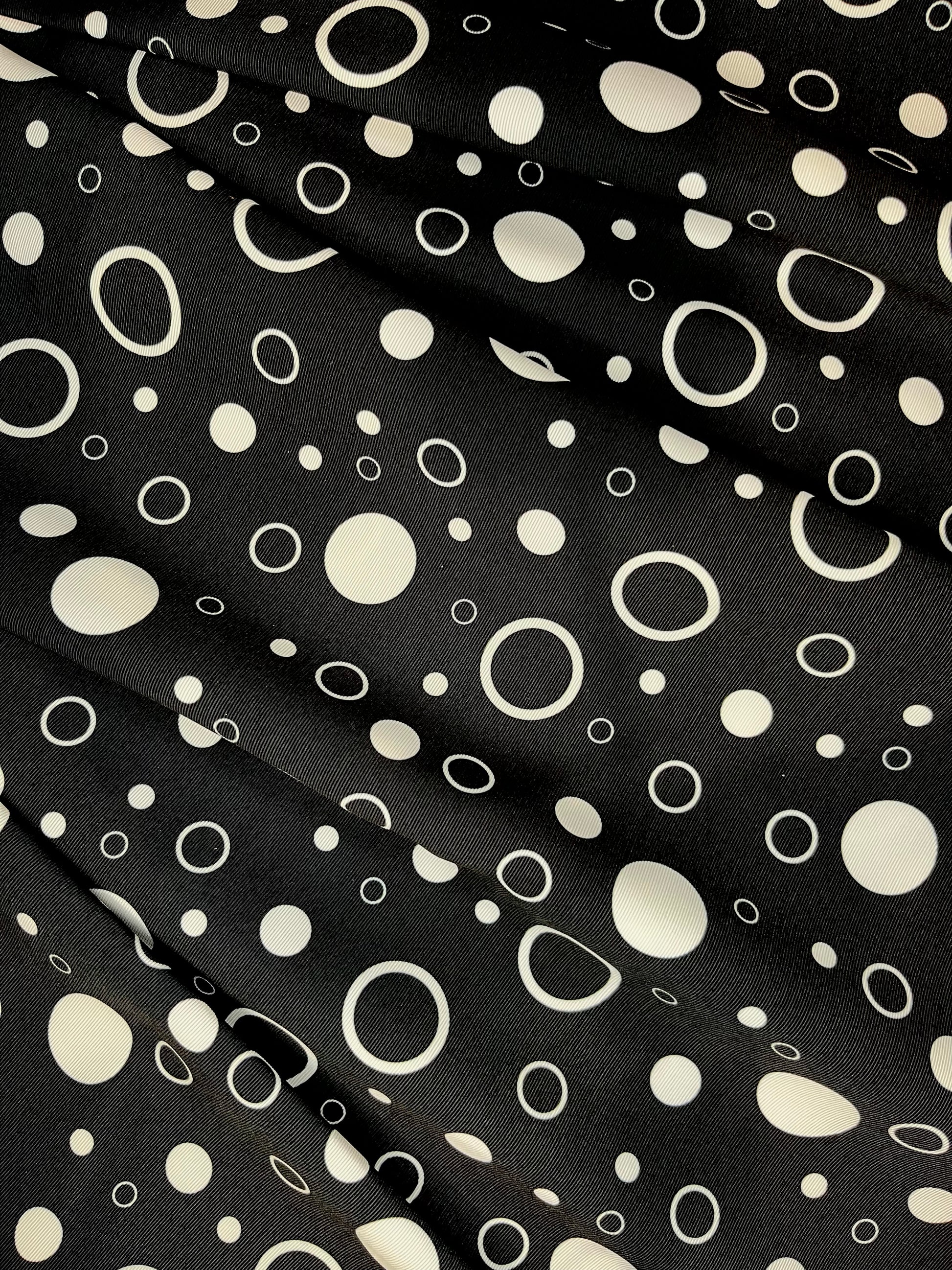 Black fabric with white polka dot pattern.