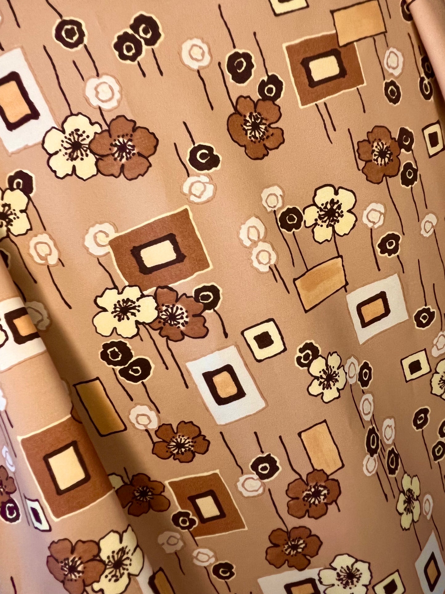 Brown/beige fabric featuring geometric shapes and flowers.